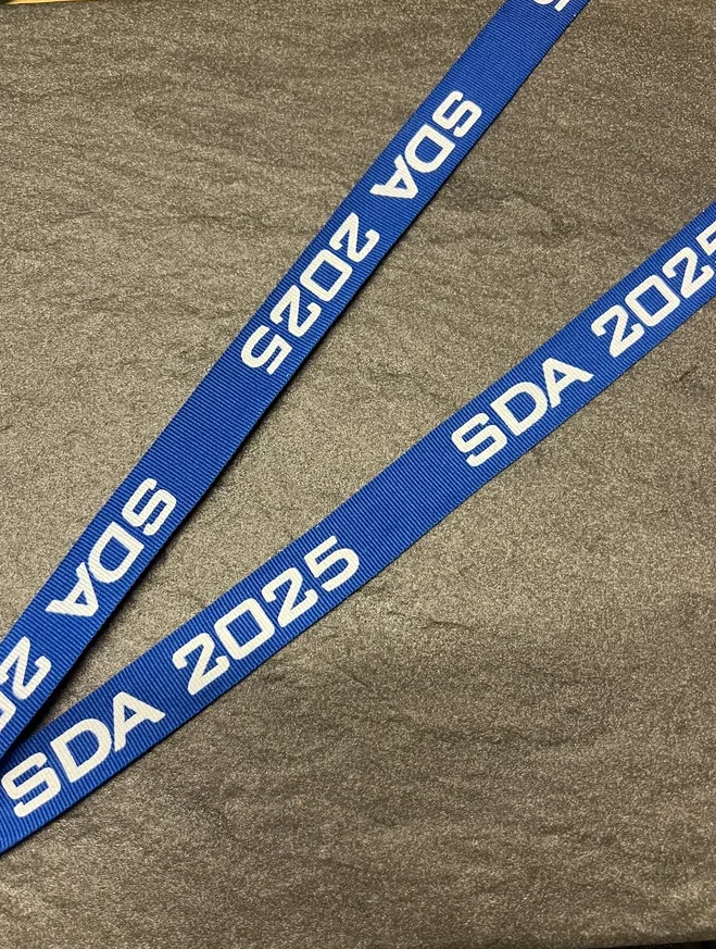 SDA 2025 printed on a blue woven ribbon