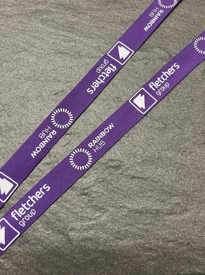 Fletchers Group and Rainbow Hub printed on a purple woven ribbon