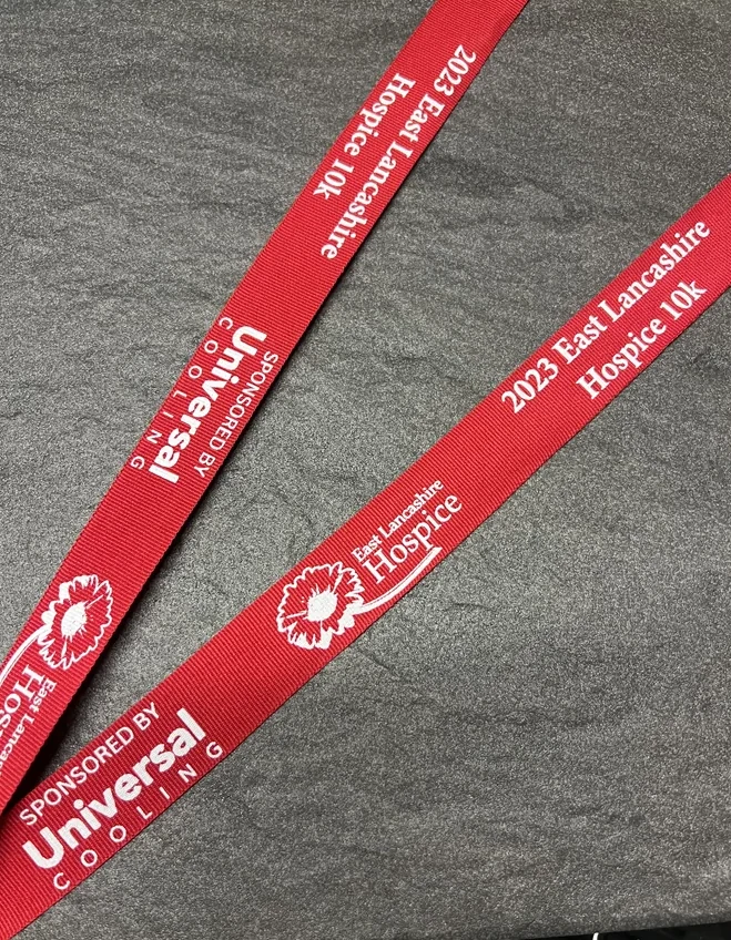 2023 East Lancashire Hospice 10k sponsored by Universal Cooling printed on a red woven ribbon