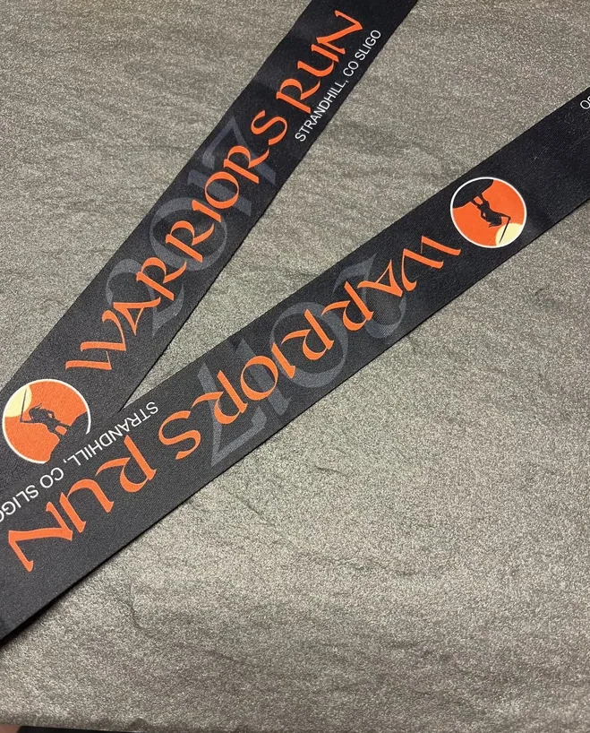 Warriors Run Strandhill Co Sligo on a black sublimation ribbon with orange lettering